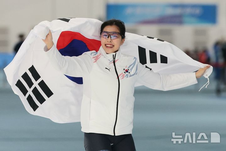 [하얼빈(중국)=뉴시스] 김선웅 기자 = 11일(현지 시간) 중국 하얼빈 헤이룽장 스피드스케이팅 오벌에서 열린 2025 하얼빈 동계 아시안게임 스피드스케이팅 여자 1000m 경기에서 동메달을 획득한 이나현이 태극기를 두르고 세레머니를 하고 있다. 2025.02.11. mangusta@newsis.com