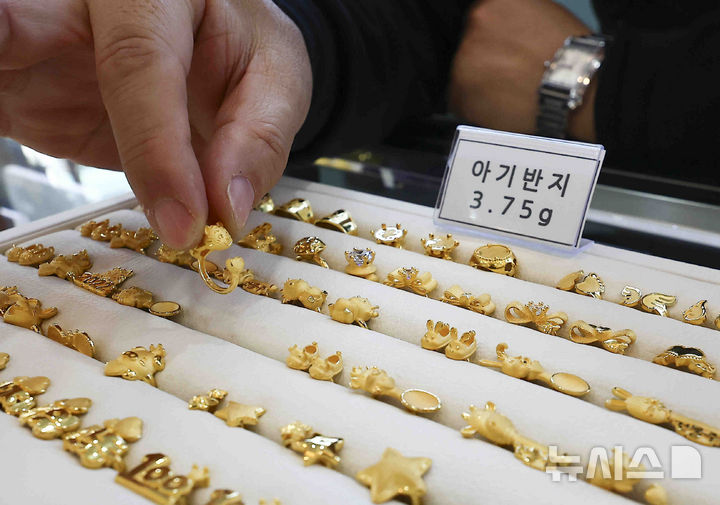[서울=뉴시스] 김근수 기자 = 11일 서울 종로구 한국금거래소 종로본점에서 직원이 금 돌반지를 들어보이고 있다. 국내 금가격도 연일 사상 최고치를 갈아치고 있다. 11일 오후 현재 한국금거래소 홈페이지 기준 금1돈 구매비용은 592,000원을 기록하고 있다. 2025.02.11. ks@newsis.com