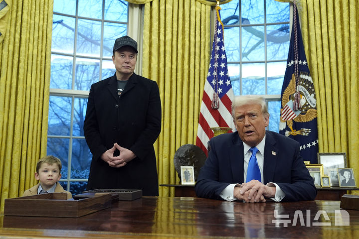 [워싱턴=AP/뉴시스] 일론 머스크가 11일(현지 시간) 워싱턴DC 백악관 대통령 집무실에서 트럼프 대통령의 발언을 듣고 있다. 왼쪽은 머스크 아들 엑스 애쉬 에이 트웰브(X Æ A-Xii), 오른쪽은 도널드 트럼프 미국 대통령. 2025.02.12.