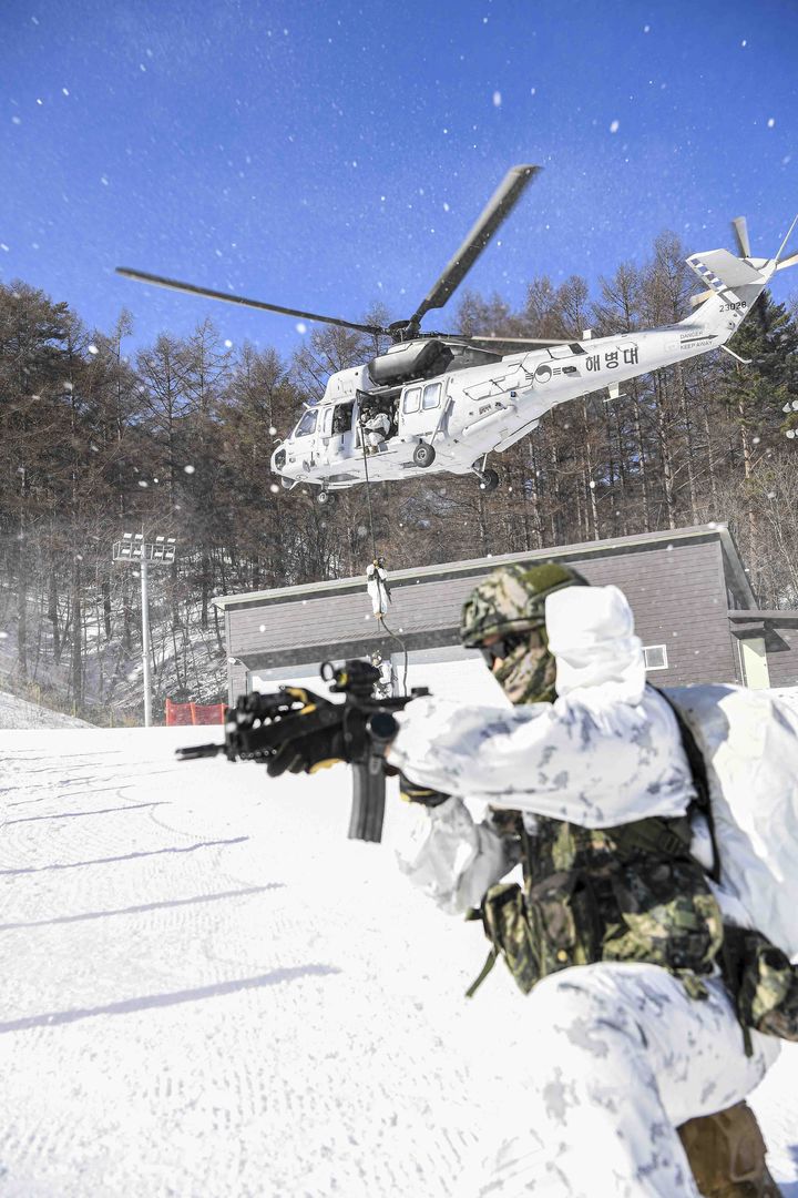 [서울=뉴시스] 해병대 사령부는 해병대 특수수색대대와 1·2사단 수색대대가 지난 4일부터 28일까지 강원도 평창 산악종합훈련자오가 황병산 일대에서 '25년 동계 설한지 훈련을 실시하고 있다고 12일 밝혔다.해병대 수색대대 장병들이 상륙기동헬기(마린온)로 기동 후, 패스트로프로 신속히 침투하며 주변을 경계하고 있다. (사진=해병대사령부 제공) 2025.02.12. photo@newsis.com *재판매 및 DB 금지