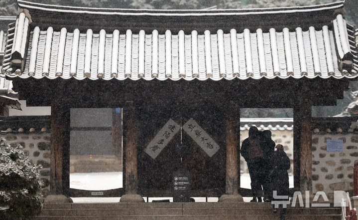 [서울=뉴시스] 이영환 기자 = 눈이 내린 12일 오전 서울 중구 남산한옥마을에서 관광객들이 이동하고 있다. 2025.02.12. 20hwan@newsis.com