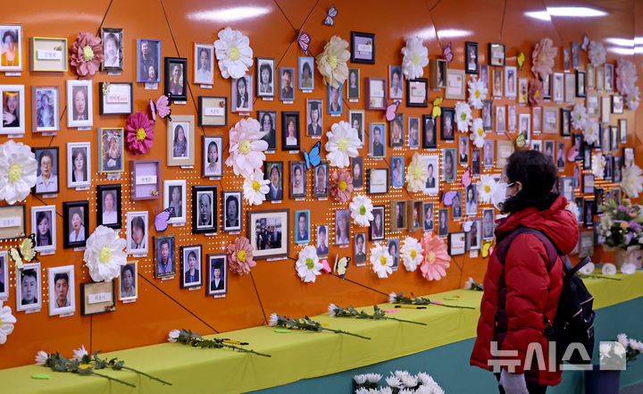 [대구=뉴시스] 이무열 기자 = 2·18 대구지하철 화재 참사 22주기를 나흘 앞둔 12일 대구도시철도 1호선 중앙로역에 마련된 기억공간을 찾은 한 시민이 희생자 영정을 바라보고 있다. 2025.02.12. lmy@newsis.com
