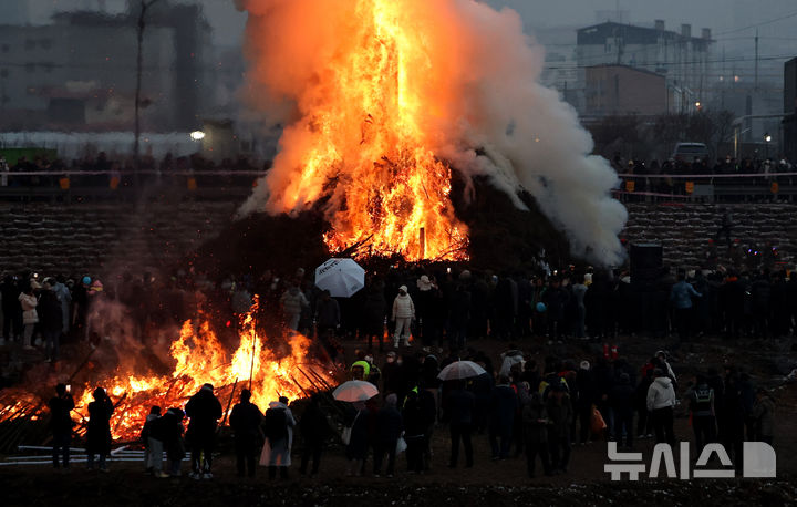 [청도=뉴시스] 지난 2025년 2월12일 경북 청도군 청도천 둔치에서 열린 정월대보름 민속한마당을 찾은 군민과 관람객들이 활활 타오르는 달집을 바라보고 있다. (사진=뉴시스 DB). photo@newsis.com 