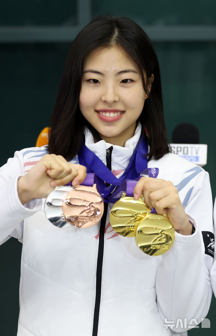 [인천공항=뉴시스] 홍효식 기자 = 2025 하얼빈 동계아시안게임에 출전한 모든 종목에서 메달(금2·은1·동1)을 획득한 스피드스케이팅 이나현이 12일 오후 인천국제공항 제1터미널을 통해 귀국해 메달을 들어보이고 있다. 2025.02.12. yesphoto@newsis.com