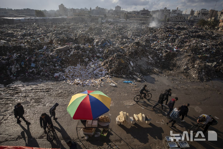 [가자시티=AP/뉴시스] 유럽의 독일과 프랑스, 영국, 이탈리아가 아랍 국가들과 도널드 트럼프 미국 대통령의 가자지구 계획에 대한 대안에 대해 아랍 국가들과 논의할 예정이라고 14일(현지 시간) 파이낸셜타임스(FT)가 보도했다. 사진은 지난 12일 가자지구 가자시티에 쌓인 쓰레기 더미 앞에서 한 상인이 식료품을 팔고 있는 모습. 2025.02.15.