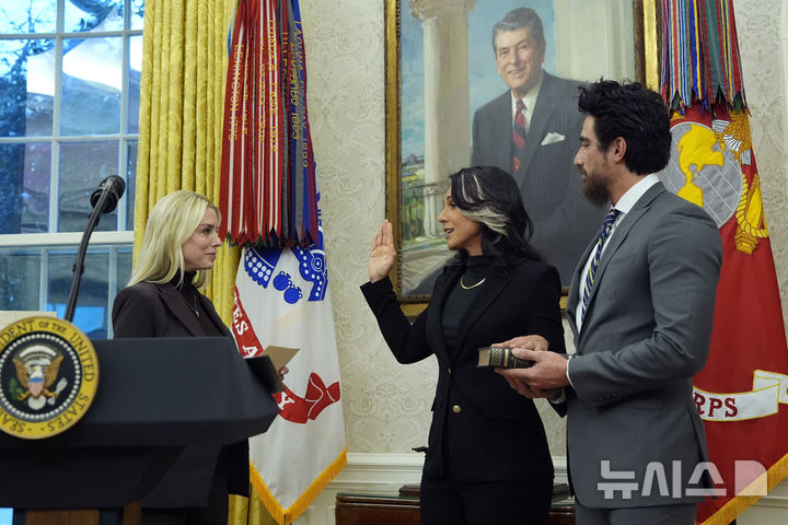 [워싱턴=AP/뉴시스] 12일(현지 시간) 백악관에서 털시 개버드 미국 국가정보국(DNI) 국장이 남편인 에이브러햄 윌리엄스가 지켜보는 가운데 팸 본디 법무장관 앞에서 취임 선서를 하고 있다. 개버드 국장은 이날 상원 인준을 받았다. 2025.02.13.