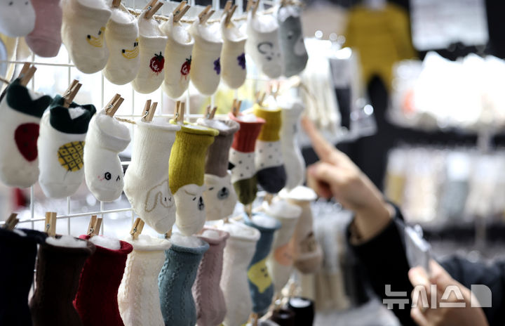[대구=뉴시스] 이무열 기자 = 13일 대구 북구 엑스코에서 열린 ‘제43회 대구 베이비＆키즈 페어’를 찾은 관람객이 유아용 양말을 살펴보고 있다. 2025,02.13. lmy@newsis.com