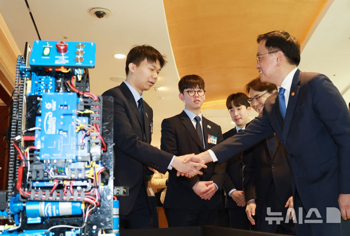 [서울=뉴시스] 조수정 기자 = 최상목 대통령 권한대행 부총리 겸 기획재정부 장관이 13일 서울 송파구 잠실 롯데호텔 월드에서 열린 '국제기능올림픽 선수단 격려 오찬'에 참석하며 로비에 전시된 모바일 로보틱스 금메달 김용현, 김겸온 씨를 격려하고 있다. (대통령실통신사진기자단) 2025.02.13. chocrystal@newsis.com
