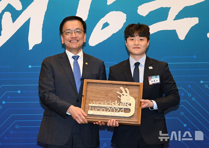 [서울=뉴시스] 조수정 기자 = 최상목 대통령 권한대행 부총리 겸 기획재정부 장관이 13일 서울 송파구 잠실 롯데호텔 월드에서 열린 '국제기능올림픽 선수단 격려 오찬'에 참석해 CNC밀링 분야 메달리스트 남종수 선수로부터 선물을 받고 있다. (대통령실통신사진기자단) 2025.02.13. chocrystal@newsis.com