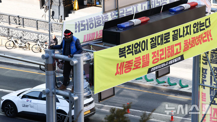 [서울=뉴시스]김근수 기자 = 코로나19로 인한 경영악화로 해고된 고진수 민주노총 세종호텔 노조 지부장이 지난해 2월 13일 서울 중구 세종호텔 앞 교통시설 구조물에 올라 정리해고 철회와 해고자 복직을 요구하며 고공농성을 하고 있다. 2025.02.13. ks@newsis.com