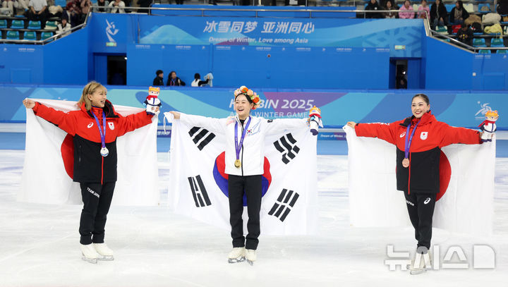 [하얼빈(중국)=뉴시스] 김선웅 기자 = 13일(현지 시간) 중국 하얼빈 헤이룽장 빙상훈련센터에서 열린 2025 하얼빈 동계 아시안게임 피겨스케이팅 여자 싱글 시상식에서 금메달을 수상한 김채연과 일본 선수들이 각각 태극기·일장기 세레머니를 하고 있다. 2025.02.13. mangusta@newsis.com