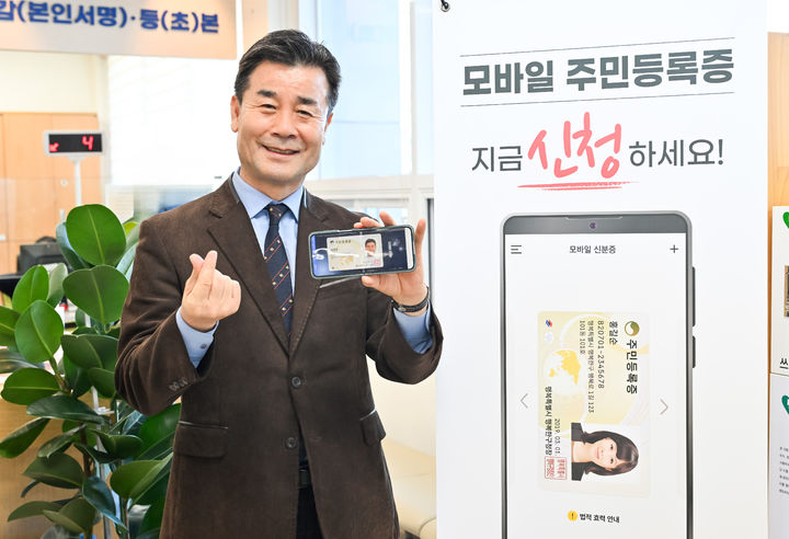 [울산=뉴시스] 구미현 기자 =울산시 중구는 모바일 주민등록증 발급을 시작했다고 14일 밝혔다. 김영길 중구청장이 이날 모바일 주민등록증을 발급한 뒤 기념촬영을 하고 있다. 2025.02.14. (사진=울산시 중구 제공) photo@newsis.com *재판매 및 DB 금지