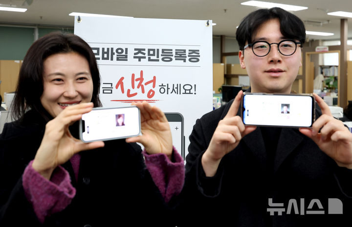 [대구=뉴시스] 이무열 기자 = 지난 2월 14일 대구 남구 봉덕2동 행정복지센터에서 시민들이 발급받은 모바일 주민등록증을 들어 보이고 있다. 2025.02.14. lmy@newsis.com
