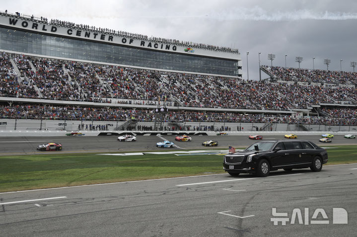 [데이토나비치=AP/뉴시스] 도널드 트럼프 미국 대통령이 16일(현지 시간) 플로리다주 데이토나 비치의 데이토나 인터내셔널 스피드웨이에서 열리는 자동차 경주 대회 '데이토나 500'을 찾아 전용 리무진 '더 비스트'를 타고 트랙을 돌고 있다. 2025.02.17.