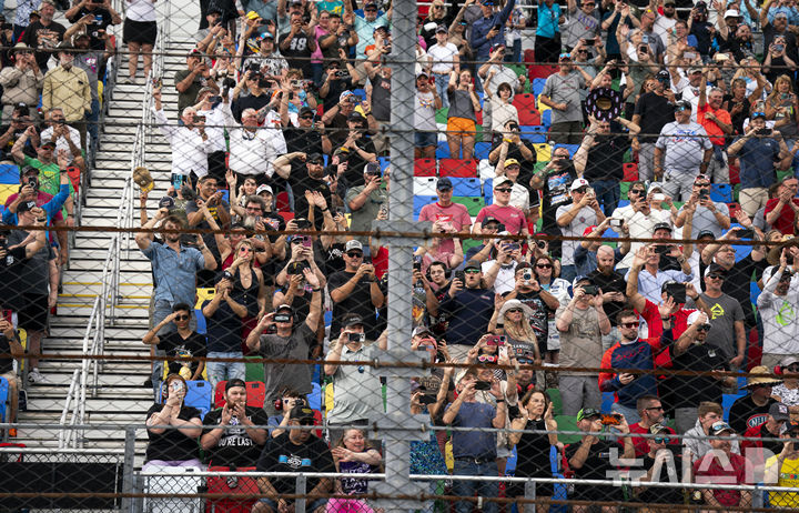 [데이토나비치=AP/뉴시스] 나스카(NASCAR) 팬들이 16일(현지 시간) 플로리다주 데이토나 비치의 데이토나 인터내셔널 스피드웨이에서 열리는 자동차 경주 대회 '데이토나 500' 시작 전 도널드 트럼프 미국 대통령이 탑승한 전용 리무진 '더 비스트'가 트랙을 도는 모습을 바라보고 있다. 2025.02.17.