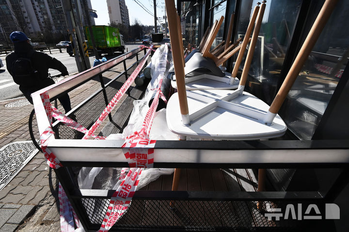 [수원=뉴시스] 김종택 기자 = 경기도 수원시의 한 폐업한 카페 매장 앞에 테이블과 의자 등이 쌓여 있다. 2025.02.17. jtk@newsis.com