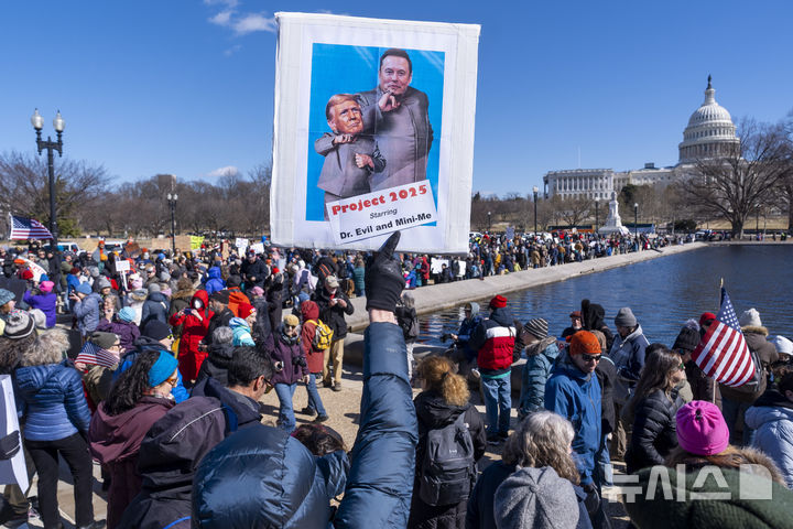 [워싱턴=AP/뉴시스] 미국 대통령의 날인 17일(현지 시간) 워싱턴 의회 인근에서 도널드 트럼프 대통령에게 반대하는 시위대가 시위를 하고 있다. '대통령의 날'은 역대 미국 대통령을 기리는 날로 초대 대통령 조지 워싱턴의 생일인 2월 22일을 전후해 2월 셋째 월요일로 지정돼 있다. 2025.02.18.
