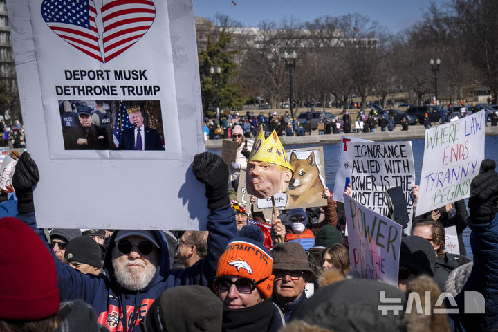 [워싱턴=AP/뉴시스] 미국 대통령의 날인 17일(현지 시간) 워싱턴 의회 인근에서 도널드 트럼프 대통령에게 반대하는 시위대가 시위를 하고 있다. '대통령의 날'은 역대 미국 대통령을 기리는 날로 초대 대통령 조지 워싱턴의 생일인 2월 22일을 전후해 2월 셋째 월요일로 지정돼 있다. 2025.02.18.