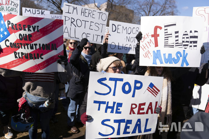 [워싱턴=AP/뉴시스] 미국 대통령의 날인 17일(현지 시간) 워싱턴 의회 인근에서 도널드 트럼프 대통령에게 반대하는 시위대가 시위를 하고 있다. '대통령의 날'은 역대 미국 대통령을 기리는 날로 초대 대통령 조지 워싱턴의 생일인 2월 22일을 전후해 2월 셋째 월요일로 지정돼 있다. 2025.02.18.