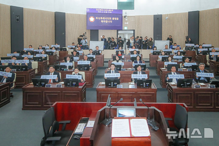 [화성=뉴시스] 화성시의회 의원들이 18일 본회의장에서 제239회 임시회 시작에 앞서 '화성특례시의회 출범'이라는 피켓을 들고 특례시의회 출범을 자축하고 있다. (사진=화성시의회 제공) 2025.02.18. photo@newsis.com