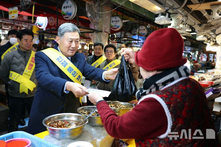 [제주=뉴시스] 김완근 제주시장이 18일 오후 제주시 동문시장에서 지역경제 활성화를 위한 경제·소비촉구 캠페인을 진행하며 시장 상인에게 젓갈류 상품을 구매하고 있다. (사진=제주시 제공) 2025.02.18. photo@newsis.com *재판매 및 DB 금지