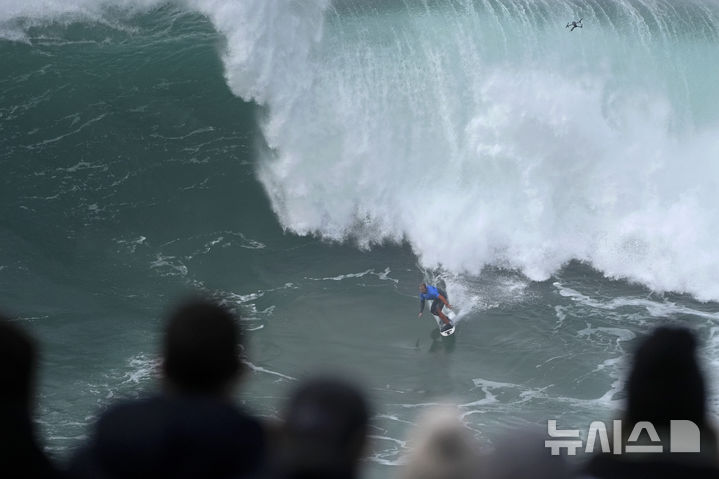 [나자레=AP/뉴시스] 18일(현지 시간) 포르투갈 나자레의 노스 비치에서 '나자레 빅웨이브 챌린지 서핑' 대회가 열려 영국 서퍼 앤드류 코튼이 파도를 타고 있다. 2025.02.19.