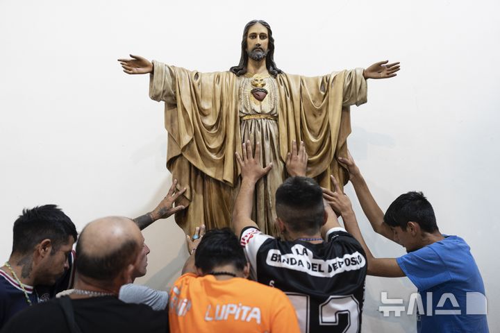 [부에노스아이레스=AP/뉴시스] 18일(현지 시간) 아르헨티나 부에노스아이레스에서 신자들이 프란치스코 교황의 건강을 기원하며 예수 그리도스의 형상을 만지고 있다. 호흡기 질환으로 닷새째 입원 중인 프란치스코 교황은 폐렴 진단을 받아 추가 약물 치료가 필요한 것으로 알려졌다. 2025.02.19.