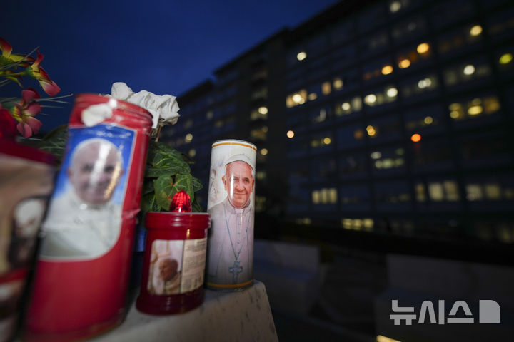 [로마=AP/뉴시스] 19일(현지 시간) 이탈리아 로마의 제멜리 병원 앞에 있는 요한 바오로 2세 교황 동상 밑에 프란치스코 교황의 건강을 기원하는 촛불이 놓여 있다. 폐렴으로 이 병원에 입원해 치료 중인 프란치스코 교황의 상태가 농담을 주고받을 정도로 나아졌다고 교황청이 밝혔다. 2025.02.20.