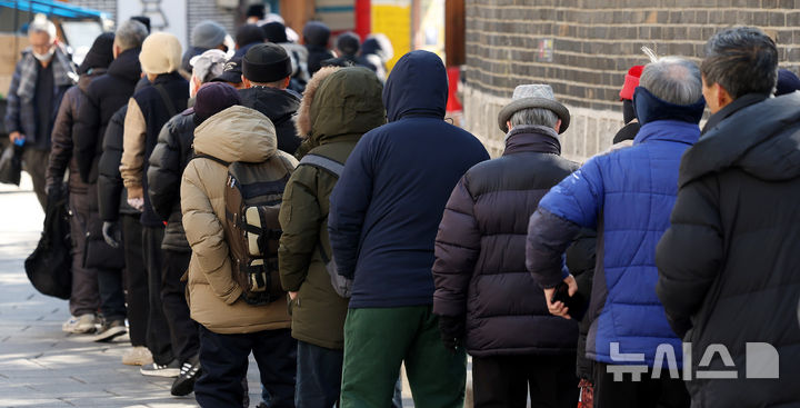 [서울=뉴시스] 추상철 기자 = 지난해 2월20일 오전 서울 종로구 탑골공원 인근 무료급식소 앞에서 노인들이 길게 줄 서 있다. 2025.02.20. scchoo@newsis.com
