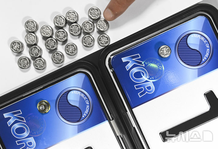 [수원=뉴시스] 김종택 기자 = 자동차 등록번호판 봉인제도 폐지를 하루 앞둔 20일 경기도 수원도시공사 번호판제작소에서 관계자가 기존 스테인리스 마개로 봉인된 번호판(사진 오른쪽)과 마개를 제거한 뒤 너트로 고정한 번호판을 보여주고 있다.도난, 번호판 위·변조 방지를 위해 1962년 시행된 자동차 등록번호판 봉인제도는 자동차관리법 일부 개정에 따라 등록번호판에 봉인을 부착하지 않고 운행할 수 있다. (공동취재) 2025.02.20. photo@newsis.com