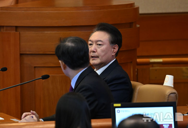 [서울=뉴시스] 사진공동취재단 = 윤석열 대통령이 20일 오후 서울 종로구 헌법재판소에서 열린 탄핵심판 10차 변론에 출석해 윤갑근 변호사와 이야기를 나누고 있다. 2025.02.20. photo@newsis.com