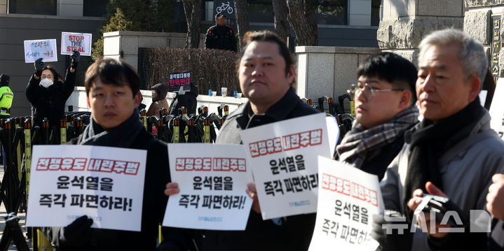 [서울=뉴시스] 홍효식 기자 = 21일 서울 종로구 헌법재판소 앞에서 자주통일평화연대 주최로 전쟁유도 내란범죄자 윤석열 파면 촉구 기자회견이 진행되는 가운데 탄핵 반대 시민들이 부정선거 중단 관련 피켓을 들고 있다. 2025.02.21. yesphoto@newsis.com