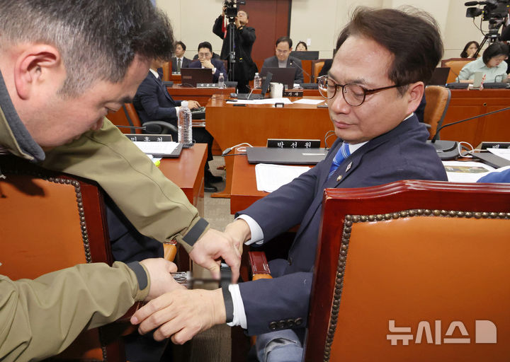 [서울=뉴시스] 조성우 기자 = 박선원 더불어민주당 의원이 21일 오전 서울 여의도 국회에서 열린 윤석열 정부의 비상계엄 선포를 통한 내란 혐의 진상규명 국정조사 특별위원회 4차 청문회에서 케이블타이 시연을 마친 뒤 보좌진의 도움을 받아 케이블타이를 자르고 있다. 2025.02.21. xconfind@newsis.com