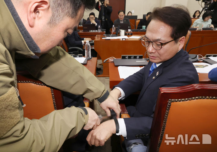 [서울=뉴시스] 조성우 기자 = 박선원 더불어민주당 의원이 21일 오전 서울 여의도 국회에서 열린 윤석열 정부의 비상계엄 선포를 통한 내란 혐의 진상규명 국정조사 특별위원회 4차 청문회에서 케이블타이 시연을 마친 뒤 보좌진의 도움을 받아 케이블타이를 자르고 있다. 2025.02.21. xconfind@newsis.com