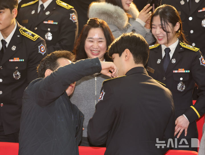 [인천=뉴시스] 전진환 기자 = 21일 오전 인천 서구 인천광역시 인재개발원에서 열린 제26기 신임소방공무원 졸업식에서 졸업생에게 가족이 계급장을 달아주고 있다. 2025.02.21. amin2@newsis.com