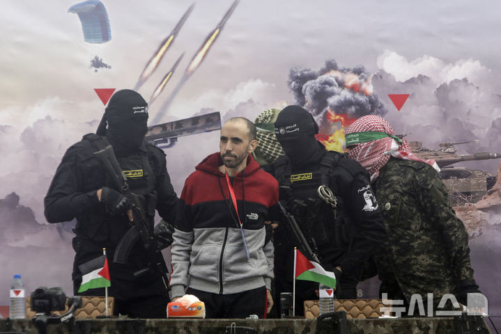 [라파=AP/뉴시스]지난 22일 가자지구 라파에서 이스라엘 인질 탈 쇼햄이 적십자사에 넘겨지고 있다. 이스라엘과 하마스는 하마스에 억류됐다가 사망한 인질들의 시신과 팔레스타인 수감자 수백명을 교환하기로 합의했다고 양측 관리들이 25일(현지시각) 말했다. 2025.02.26.