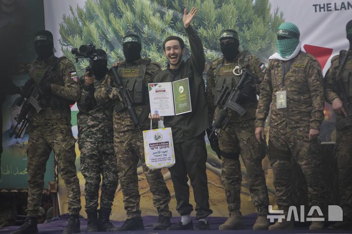 [누세이라트=AP/뉴시스] ﻿﻿이스라엘이 하마스와 합의된 팔레스타인 수감자 석방을 전격 연기했다. 하마스 측이 이스라엘 인질을 석방하는 과정에서 굴욕적인 행사로 인질을 모욕한 것을 문제 삼았다. 사진은 22일(현지 시간) 가자지구 누세이라트에서 이스라엘 인질 오메르 솀이 석방 전 군중을 향해 손을 흔드는 모습. 2025.02.23