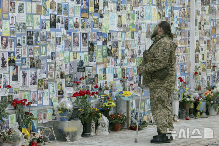 [키이우=AP/뉴시스] 러시아의 우크라이나 침공 3주년이 되는 24일(현지 시간) 우크라이나 키이우 독립광장 내 우크라이나 전몰장병 추모비 앞에서 한 상이군인이 전우들을 추모하고 있다. 2025.02.25.