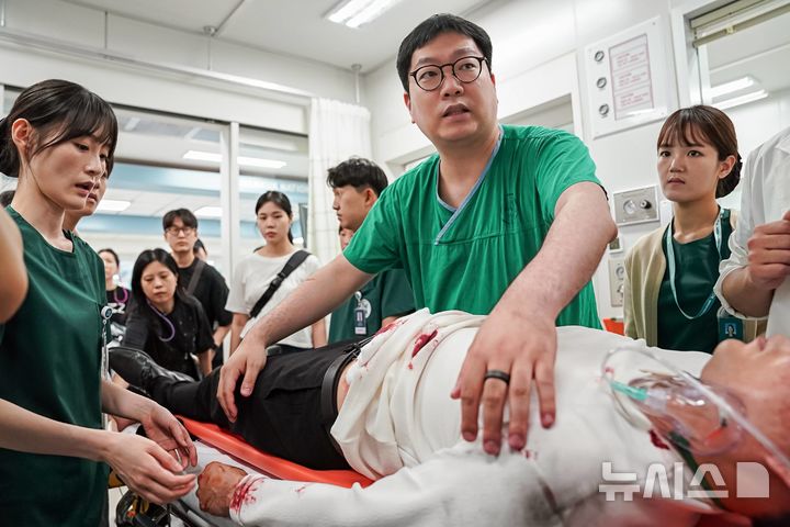 [서울=뉴시스]이대서울병원 김태윤 중환자외과 교수를 단장으로 송승환 외과 교수, 조동영 신경외과 교수, 황역구 정형외과 교수, 이대목동병원 이재길 외상외과 교수 등이 의학적 고증과 의학적 디테일을 살리기 위해 드라마 '중증외상센터' 자문단으로 참여했다. 사진은 환자를 진료하는 김태윤 교수.(사진= 이대서울병원 제공) 2025.02.24. photo@newsis.com. 