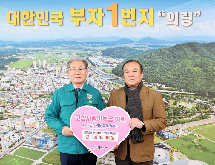 [의령=뉴시스]전랑수(오른쪽)씨가 아들을 대신해 고향사랑기부금을 오태완 의령군수에게 전달하고 있다.(사진=의령군 제공) 2025.02.24.photo@newsis.com *재판매 및 DB 금지