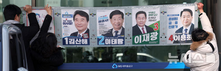 [서울=뉴시스] 김선웅 기자 = 24일 서울 종로구 종로중앙새마을금고 혜화지점에서 서울시 선거관리위원회 직원들이 3월 5일 실시되는 제1회 전국동시 새마을금고 이사장 선거 벽보를 부착하고 있다. 2025.02.24. mangusta@newsis.com