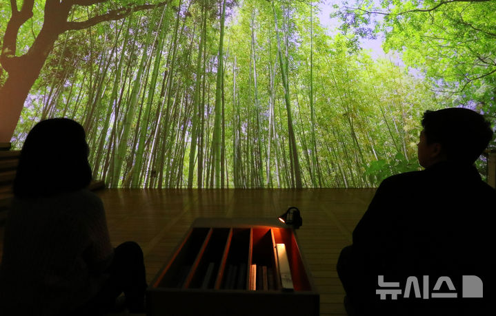 [서울=뉴시스] 김혜진 기자 = 24일 오전 서울 종로구 세종미술관에서 열린 디지털로 재현한 '미음완보(微吟緩步), 전통정원을 거닐다' 언론 공개회에서 참석자가 미디어아트를 관람하고 있다.&nbsp; 국가유산청은 세종문화회관과 '미음완보' 전을 오는 4월 27일까지 개최한다고 밝혔다. '미음완보'전은 '산수지락(山水之樂) 자연을 벗 삼아 누리는 즐거움', '격물치지(格物致知), 정원에서 얻는 아취', '인지제의(因地制宜), 자연에 의탁한 정원' 등 총 3부로 구성된다. 2025.02.24. jini@newsis.com