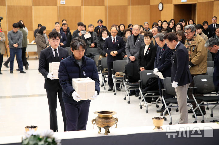 [제주=뉴시스] 우장호 기자 = 24일 오후 제주시 봉개동 제주4·3 평화교육센터에서 열린 '4·3 희생자 신원확인 결과 보고회'에서 유해함을 든 희생자 유족들이 입장하고 있다. 2025.02.24. woo1223@newsis.com