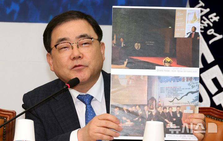 [서울=뉴시스] 조성봉 기자= 허성무 더불어민주당 명태균 게이트 진상조사단 창원산업단지 등 국정개입 조사본부위원이 24일 오후 서울 여의도 국회에서 열린 진상조사단 회의에서 홍준표 대구시장과 명태균 씨가 행사장에 함께 있는 사진을 공개하고 있다. 2025.02.24. suncho21@newsis.com