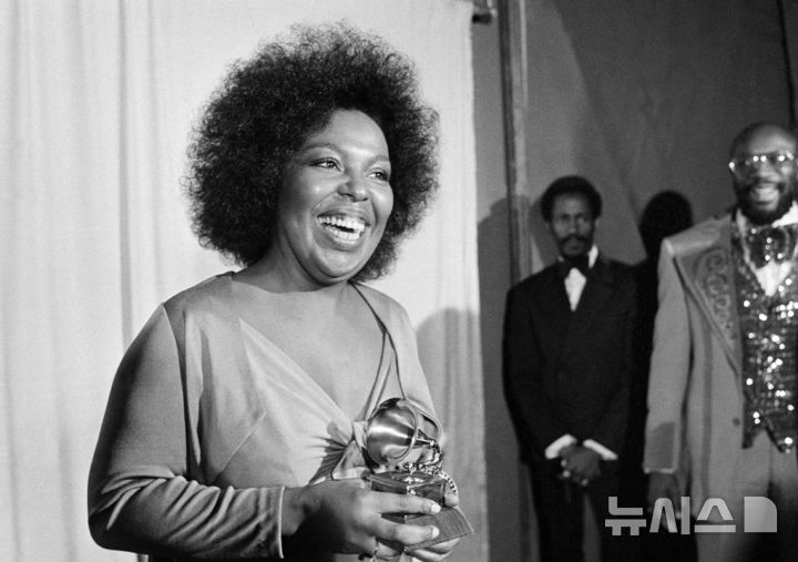 [로스앤젤레스=AP/뉴시스] 미국 팝스타 로베타 플랙이 1974년 3월4일 로스앤젤레스에서 열린 그래미 시상식에 참석해 '킬링 미 소프트리 위드 히즈 송'으로 '올해의 노래' 트로피를 받고 기뻐하고 있다. 자료사진. 2025.02.25
