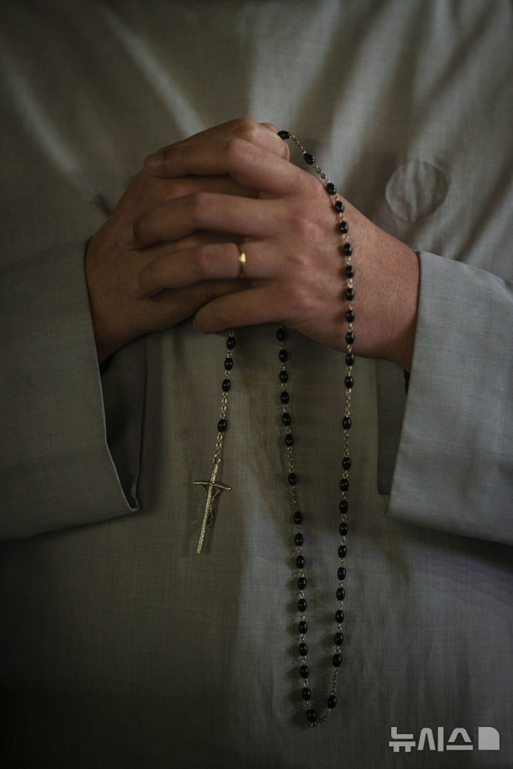 [바티칸=AP/뉴시스] 24일(현지 시간) 바티칸 성 베드로 광장에서 열린 프란치스코 교황을 위한 묵주 기도회에 참석한 가톨릭 신부가 교황의 건강 회복을 기원하며 기도하고 있다. 2025.02.25.