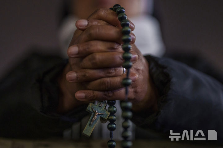 [바티칸=AP/뉴시스] 24일(현지 시간) 바티칸 성 베드로 광장에서 열린 프란치스코 교황을 위한 묵주 기도회에 참석한 수녀가 교황의 건강 회복을 기원하며 기도하고 있다. 2025.02.25.