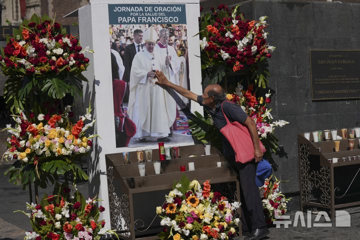 [멕시코시티=AP/뉴시스] 지난 24일(현지 시간) 멕시코 멕시코시티 과달루페 대성당에서 프란치스코 교황 건강 회복 기원 기도회가 열린 가운데 한 시민이 교황의 사진을 만지고 있다. 2025.02.26.