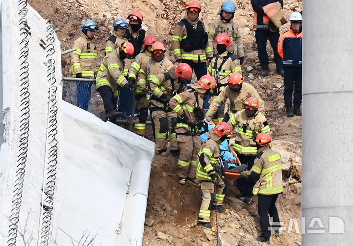 [안성=뉴시스] 김종택 기자 = 25일 경기도 안성시 서운면 산평리 서울세종고속도로 천안~안성 구간 연결공사 교량 붕괴현장에서 소방대원들이 구조된 매몰자를 옮기고 있다. 2025.02.25. jtk@newsis.com