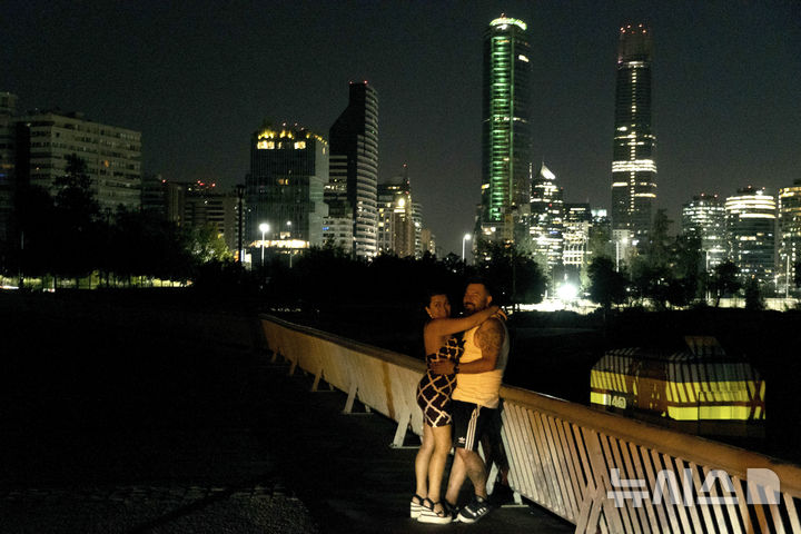 [산티아고=AP/뉴시스] 25일(현지 시간) 칠레에서 대규모 정전이 발생한 가운데 어두운 산티아고 거리에서 한 연인이 데이트를 즐기고 있다. 이날 발생한 대규모 정전으로 칠레 전역에서 큰 혼란이 빚어졌다. 칠레 정부는 이번 사태가 외부 공격에 의한 것은 아닌 것으로 보인다며 복구에 최선을 다하고 있다고 밝혔다. 2025.02.26.
